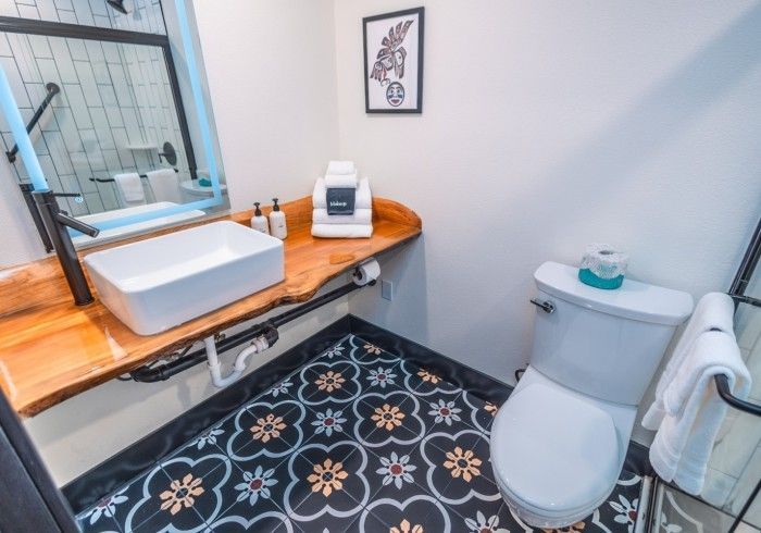 A bathroom with a toilet , sink and mirror.