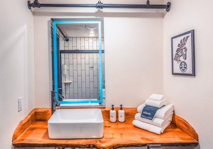 A bathroom with a sink , mirror and towels on the counter.