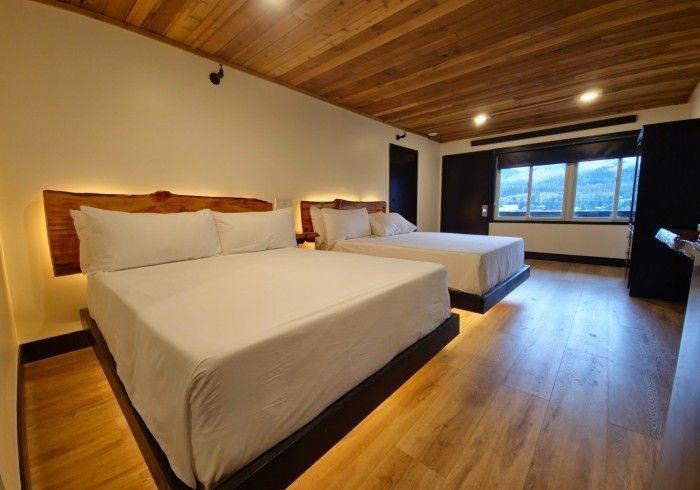 A hotel room with two beds and a wooden floor