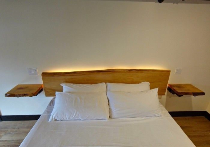 A bed with white sheets and a wooden headboard