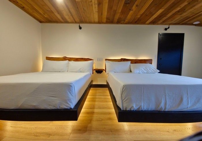 A hotel room with two beds and a wooden ceiling