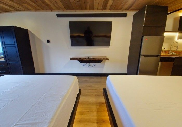 A bedroom with two beds and a flat screen tv