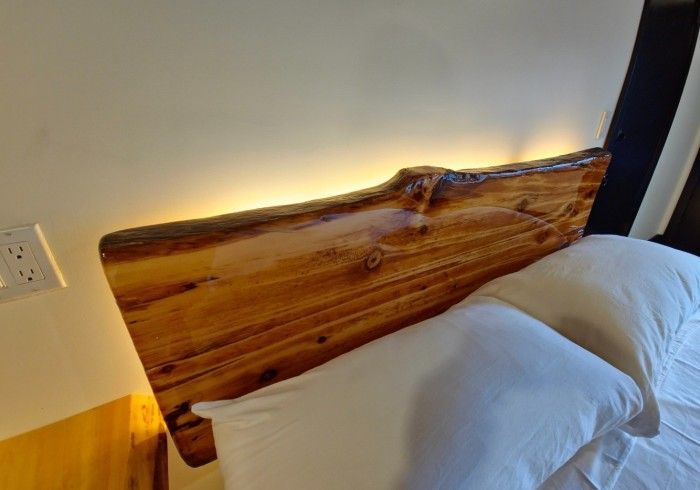 A bed with a wooden headboard and white pillows in a bedroom.