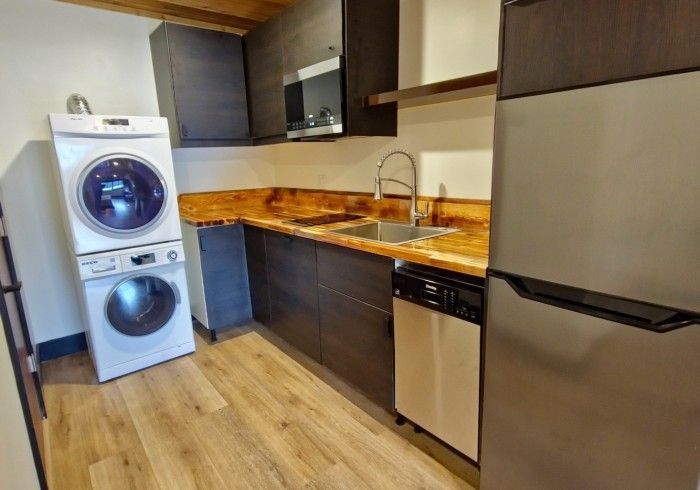 A kitchen with a washer and dryer stacked on top of each other.