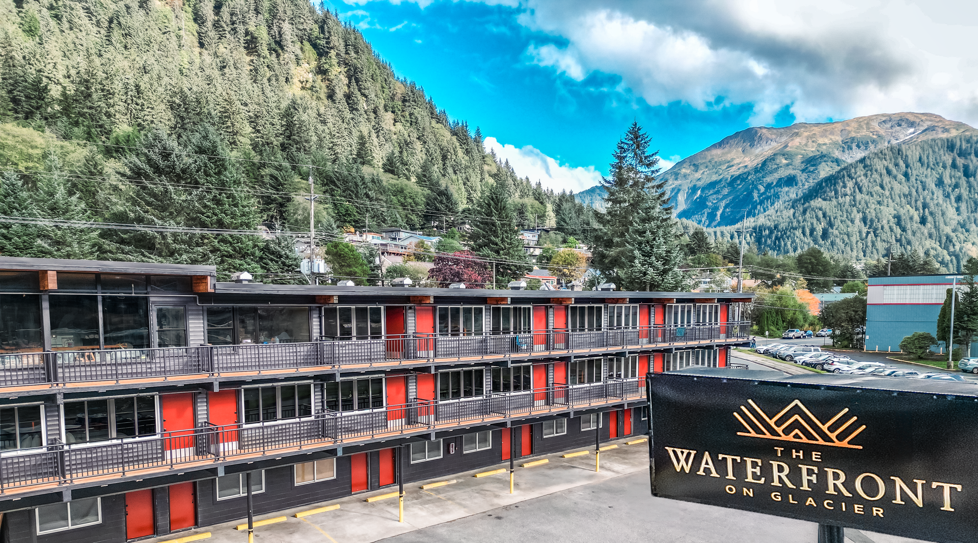 A large building with a sign in front of it and mountains in the background.