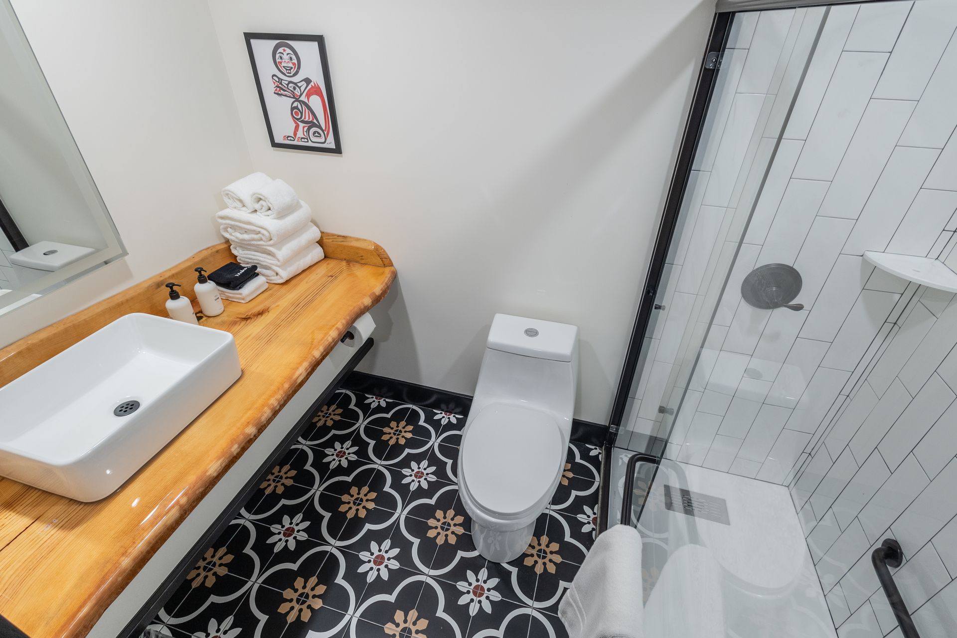 A bathroom with a toilet , sink and shower.