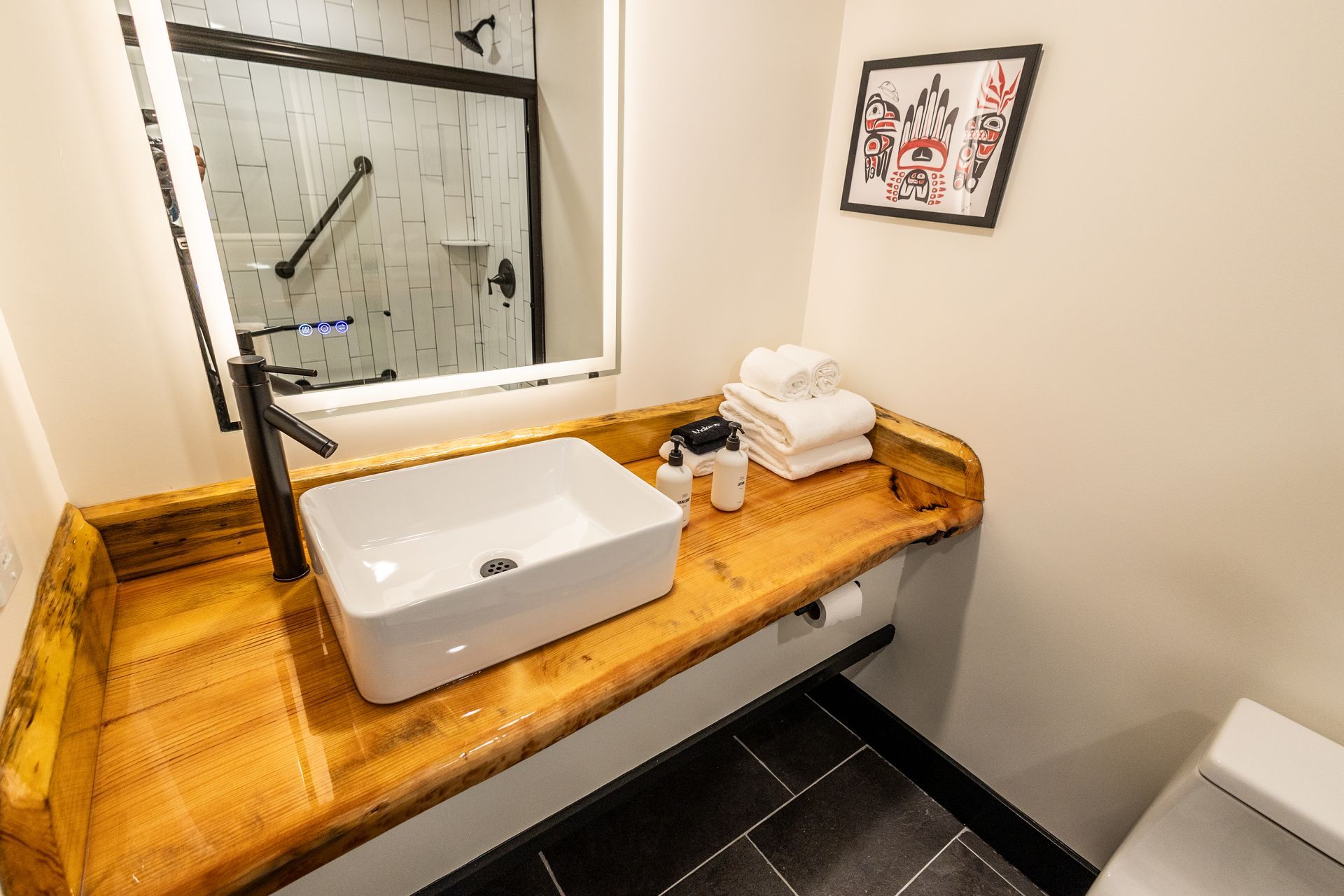 A bathroom with a sink , toilet and mirror.