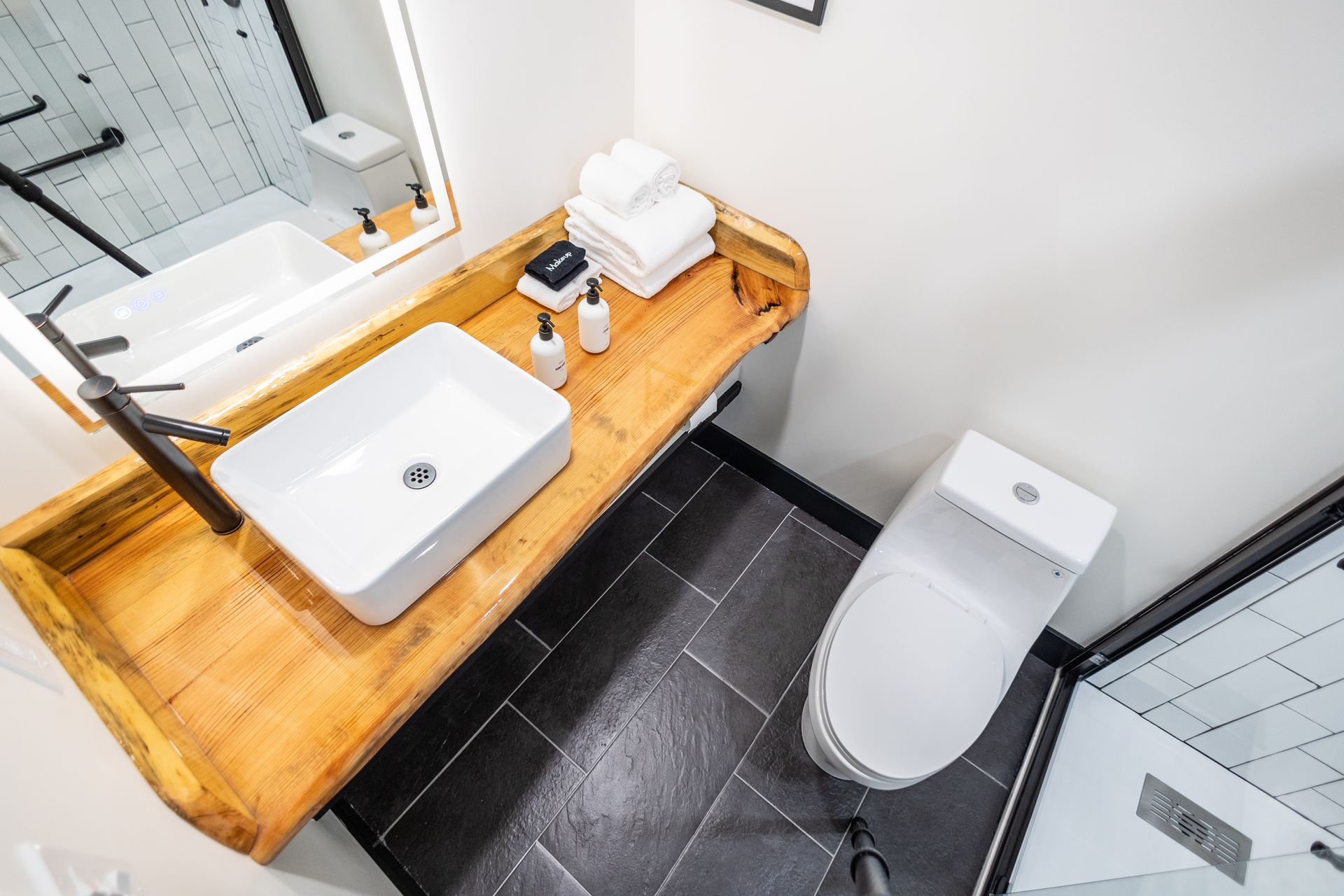 A bathroom with a toilet , sink and mirror.