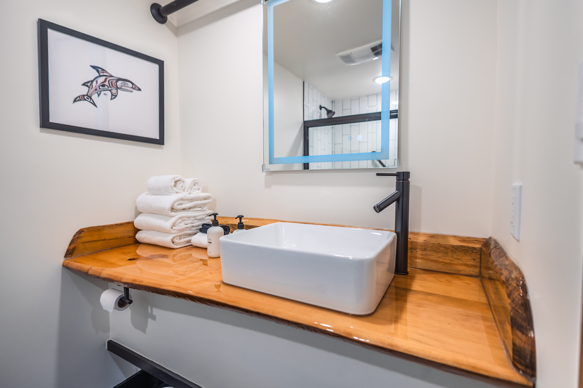 A bathroom with a sink , mirror and towels on the counter.