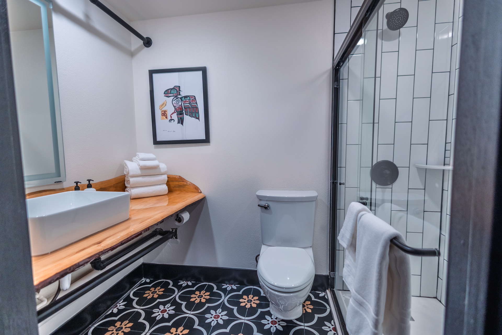 A bathroom with a toilet , sink and shower.