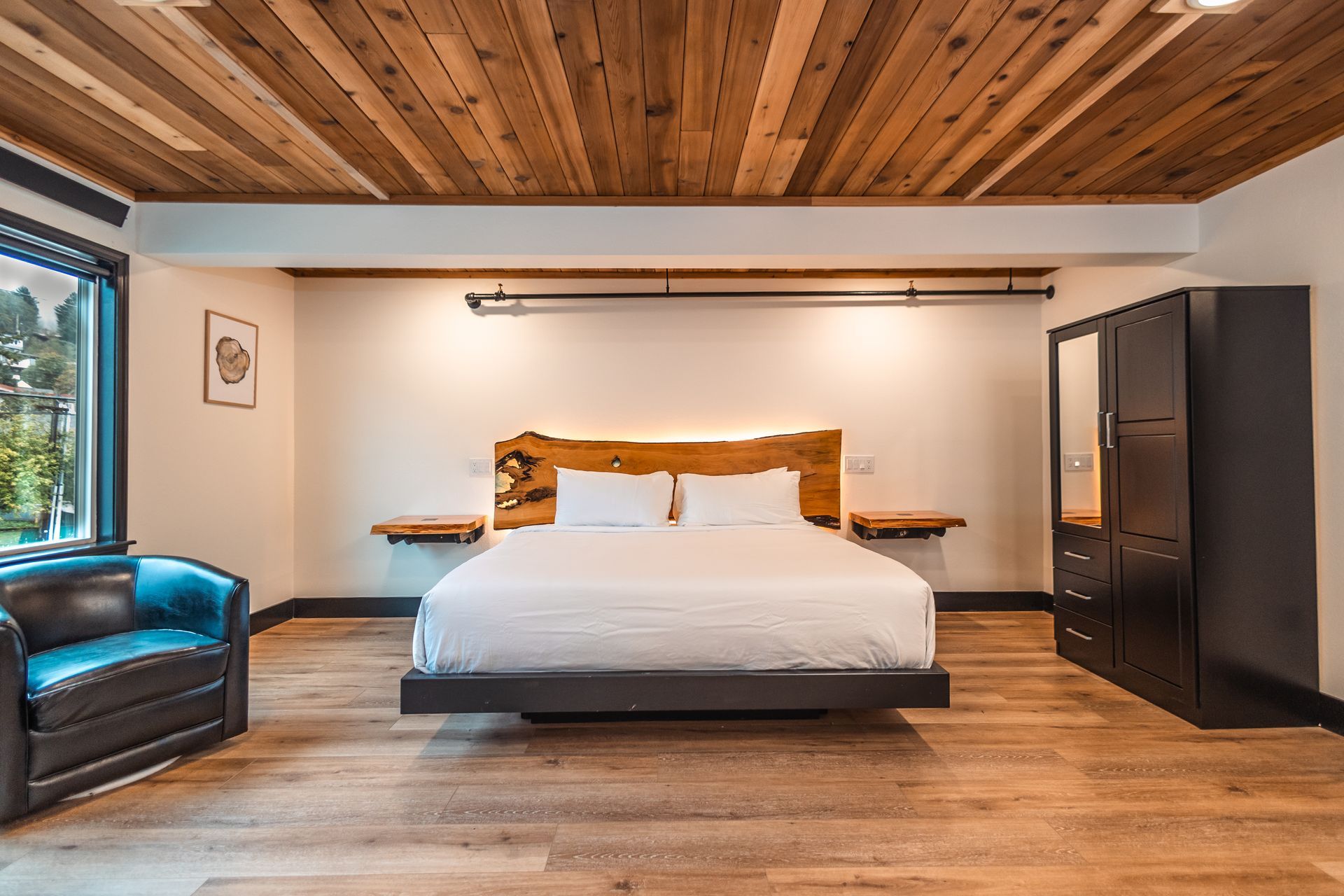 There is a large bed in the middle of the room with a wooden ceiling.