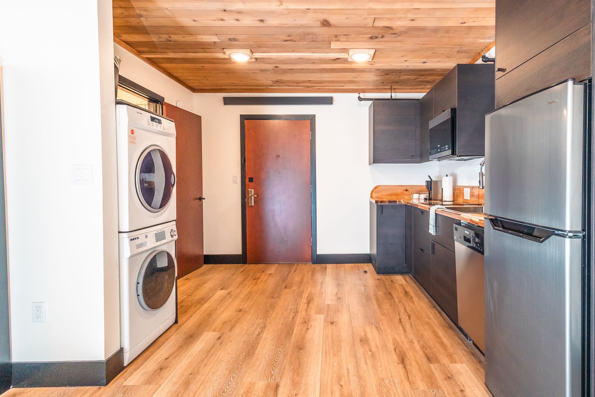 A kitchen with a washer and dryer stacked on top of each other.