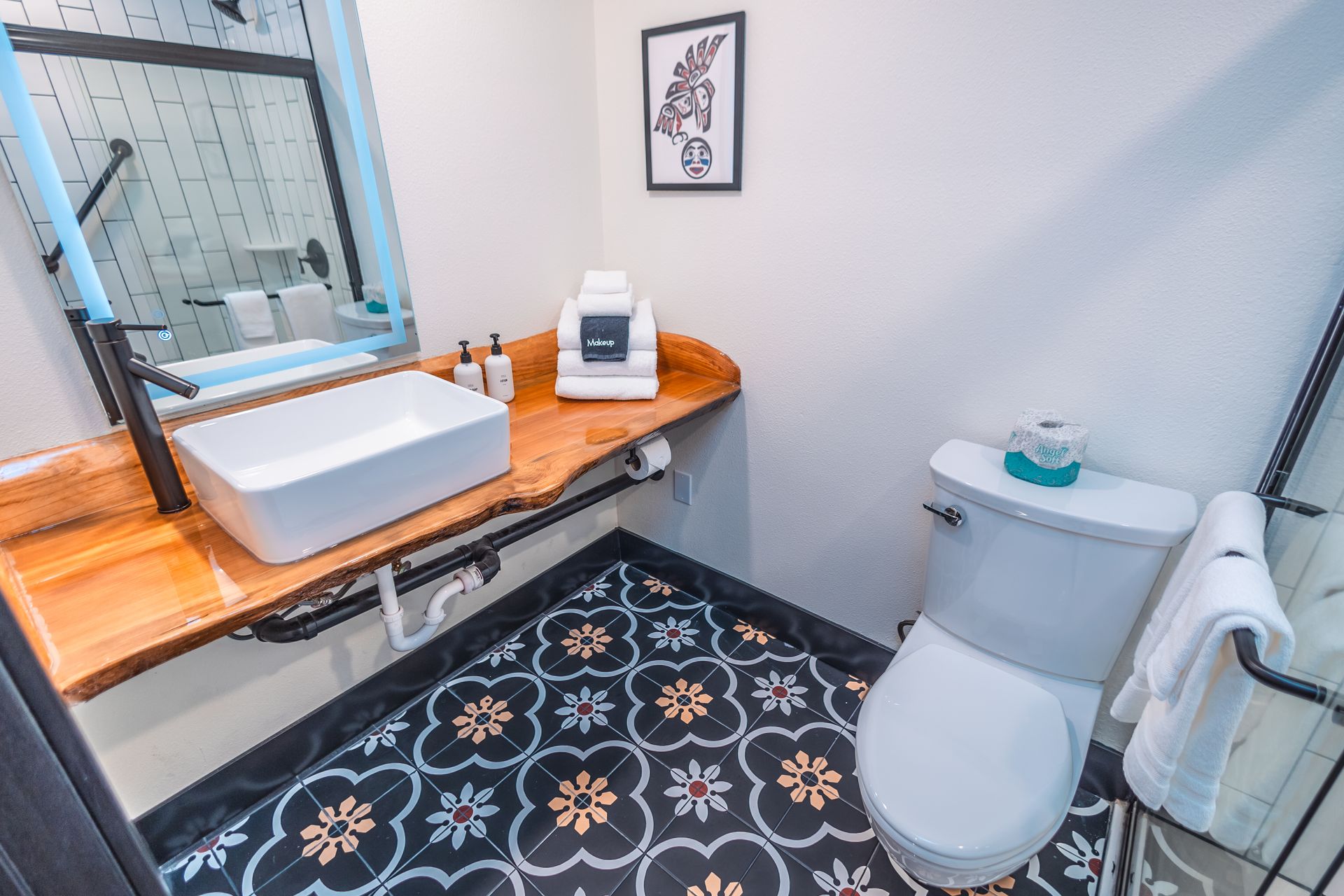 A bathroom with a toilet , sink and mirror.
