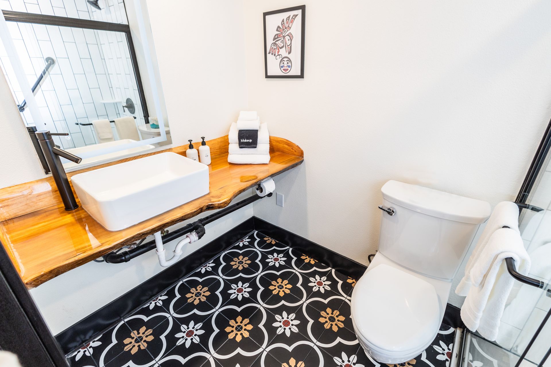 A bathroom with a toilet , sink and mirror.