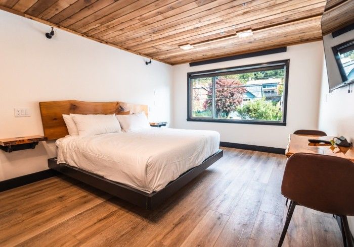 A hotel room with a king size bed , desk and chair.