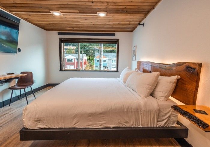 A hotel room with a king size bed and a large window.