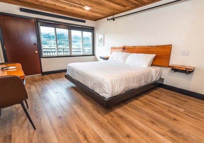 A hotel room with a bed , desk , chair and window.