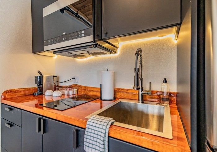 A kitchen with a sink , stove , and microwave.