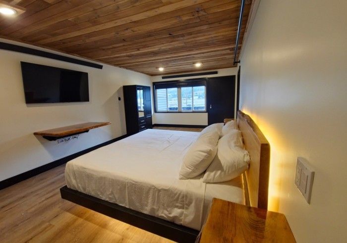 A bedroom with a king size bed and a flat screen tv