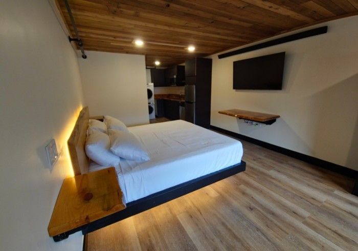 A bedroom with a bed and a television on the wall