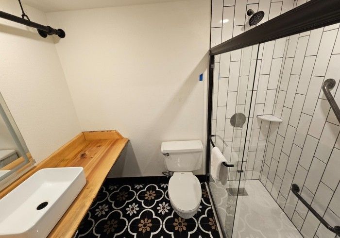 A bathroom with a toilet a sink and a shower