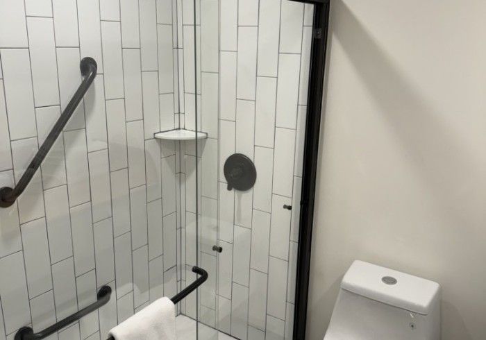 A bathroom with a toilet and a shower with a glass door.