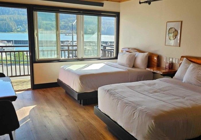 A hotel room with two beds and a large window