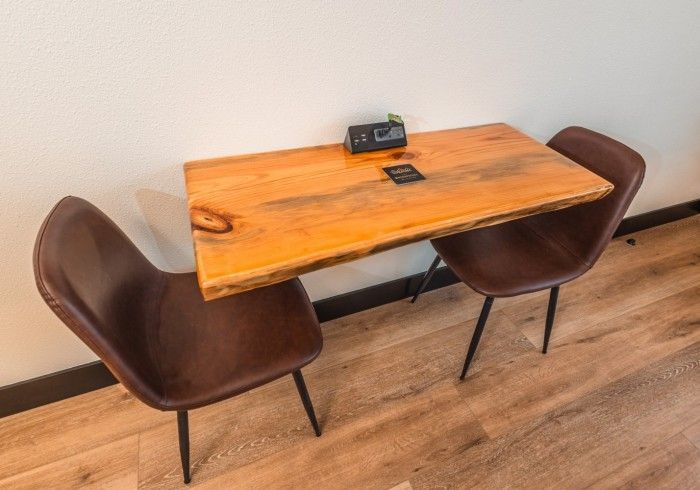 A wooden table with two chairs underneath it in a room.