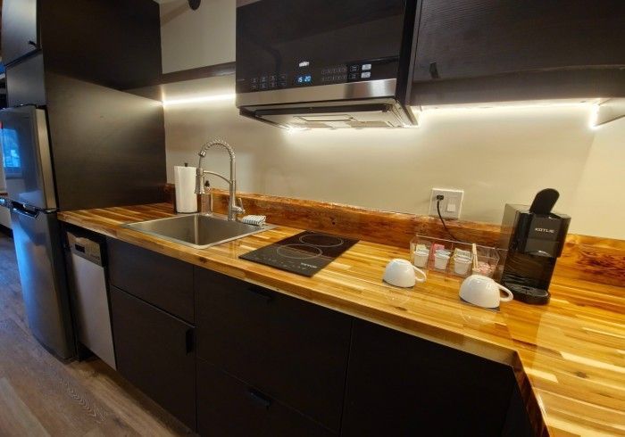 A kitchen with a sink , stove , microwave and dishwasher.