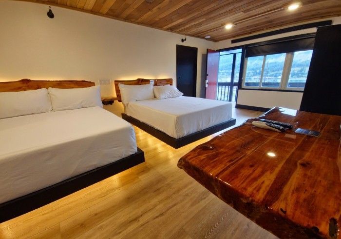 A hotel room with two beds and a wooden table.