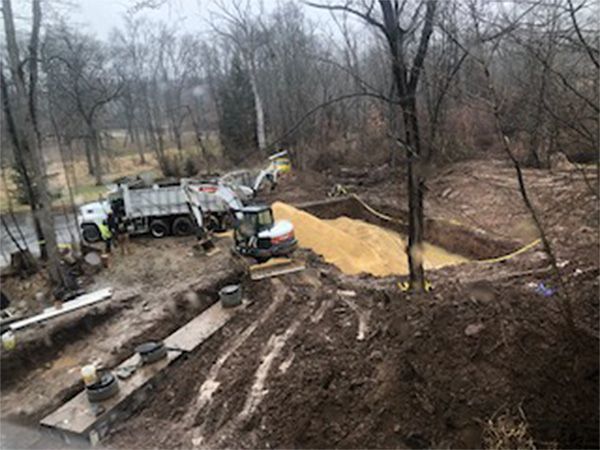 A large pile of dirt is being loaded into a dump truck.