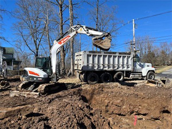An excavator is loading dirt into a dump truck.