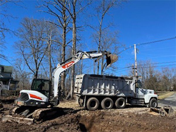 An excavator is loading dirt into a dump truck.
