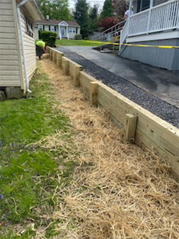 A wooden fence is being built in front of a house.