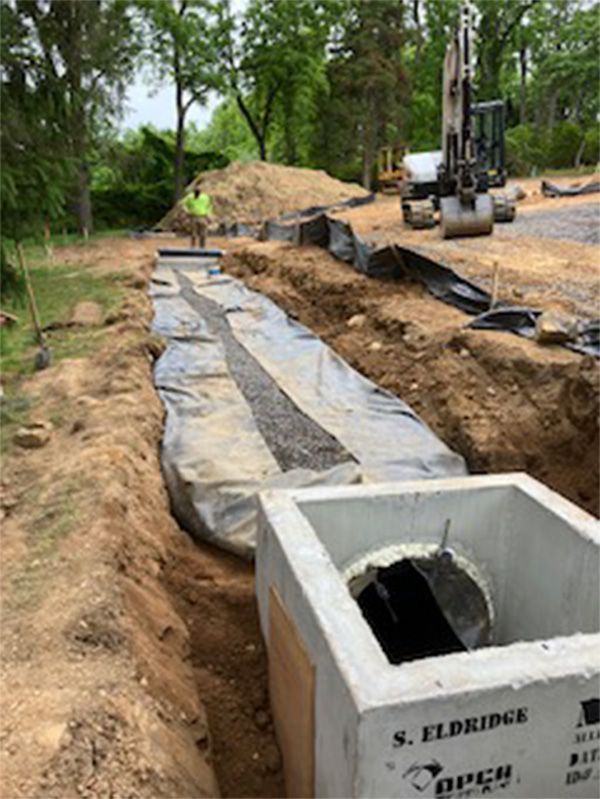 A large concrete box is sitting in the middle of a dirt field.