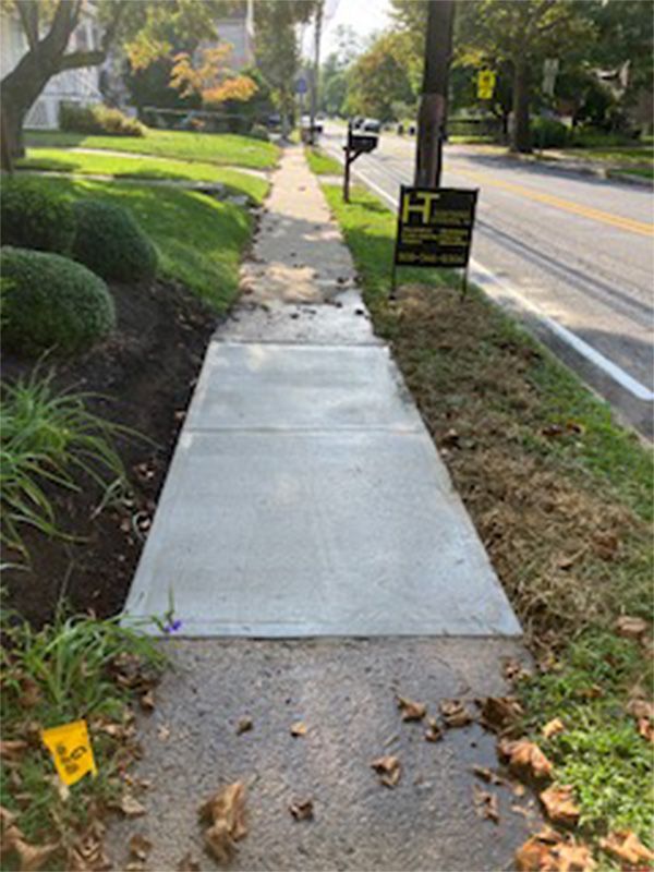 A concrete sidewalk is being built next to a street.