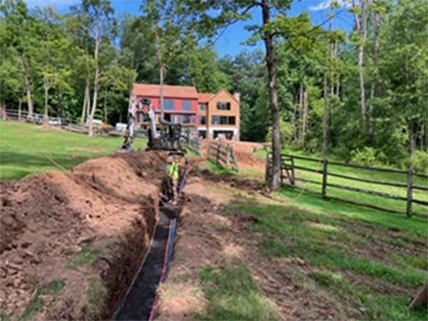 A large house is being built in the middle of a lush green field.