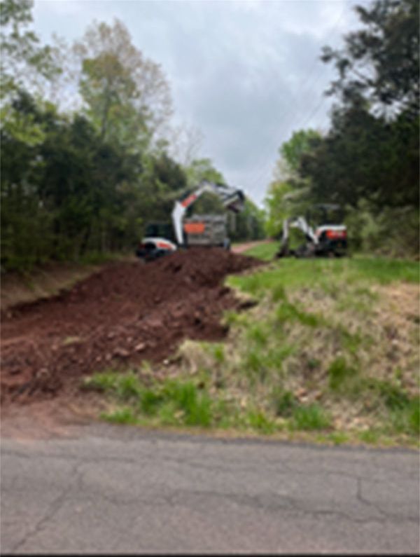 A bulldozer is moving dirt on the side of a road.