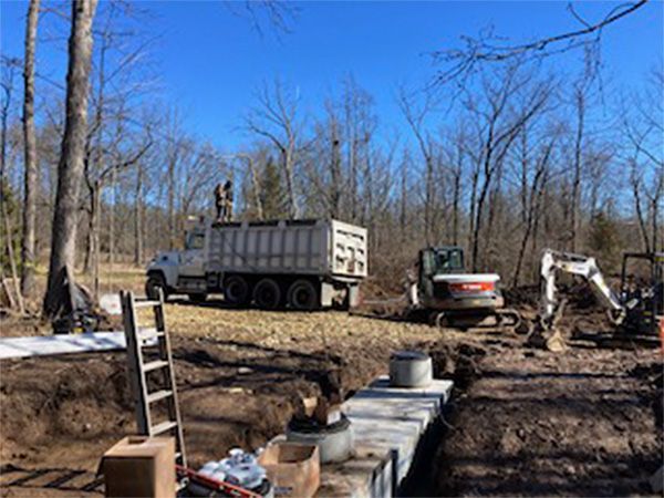 A dump truck is parked in the middle of a dirt field.