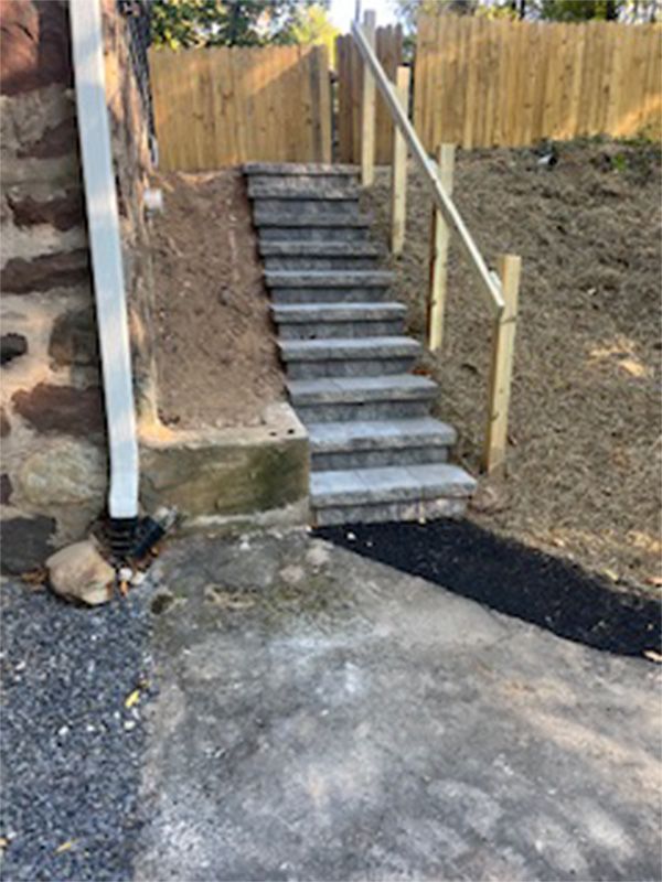 A set of stairs leading up to a house with a wooden railing.