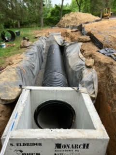 A large pipe is being installed in a trench.