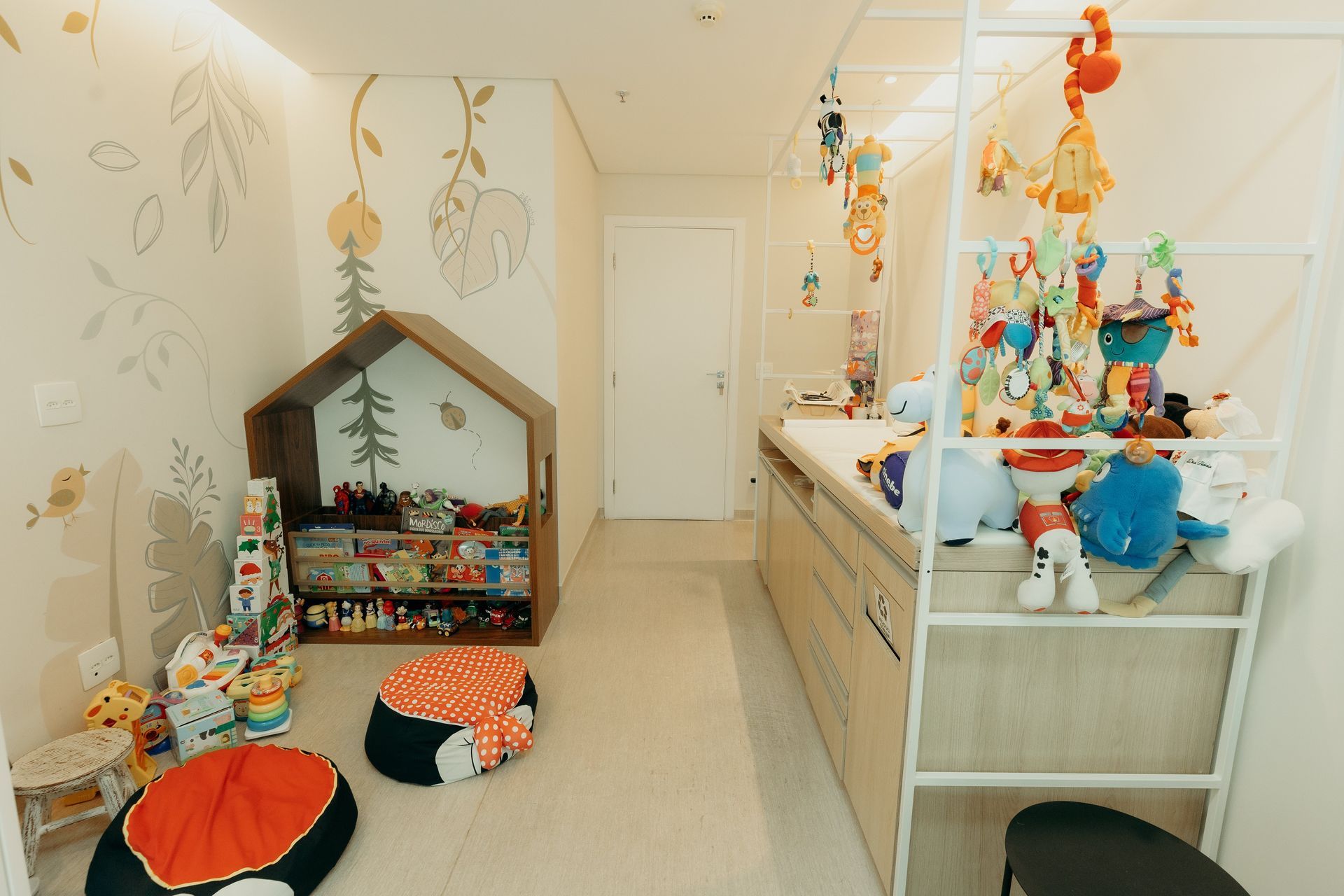 Uma sala com muitos brinquedos no chão e uma escada.