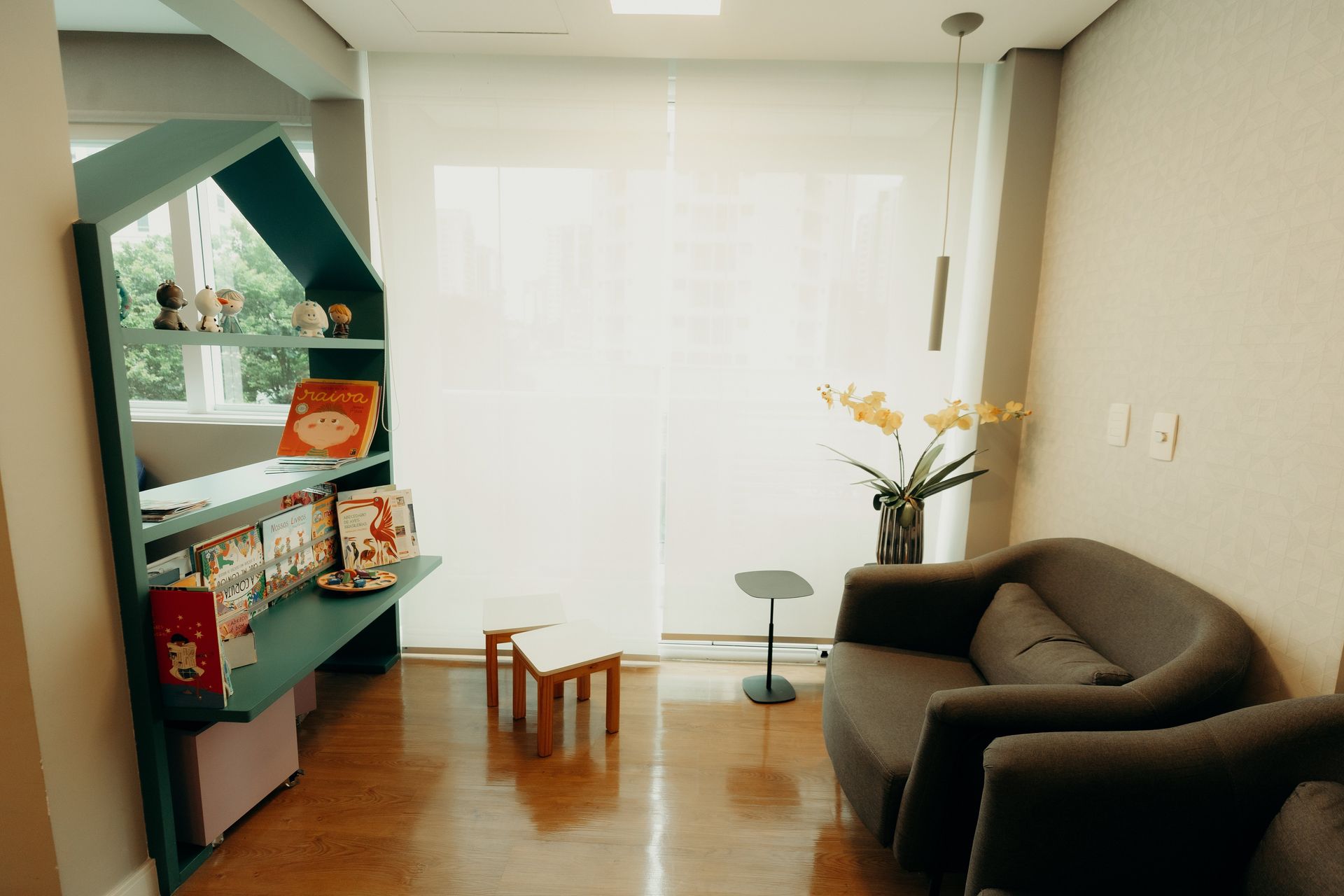 Uma sala de estar com um sofá, cadeiras e uma estante.