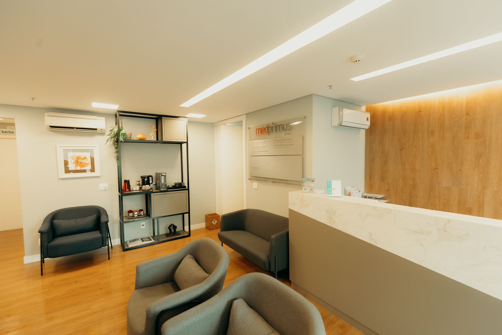 Uma sala de espera com cadeiras, um sofá e um balcão.