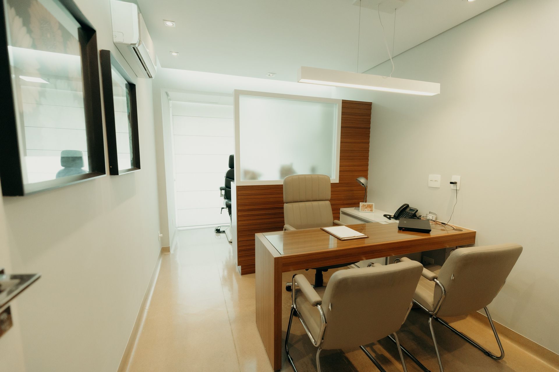 Um pequeno escritório com uma mesa e cadeiras em um corredor.