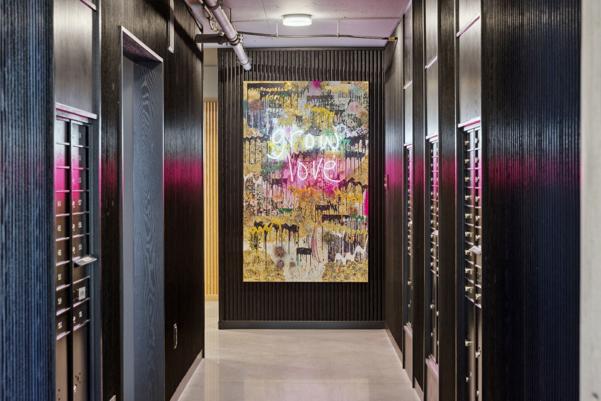Interior hallway with dark wood panels and a colorful wall art piece at the end at Esox House in St. Paul, MN.