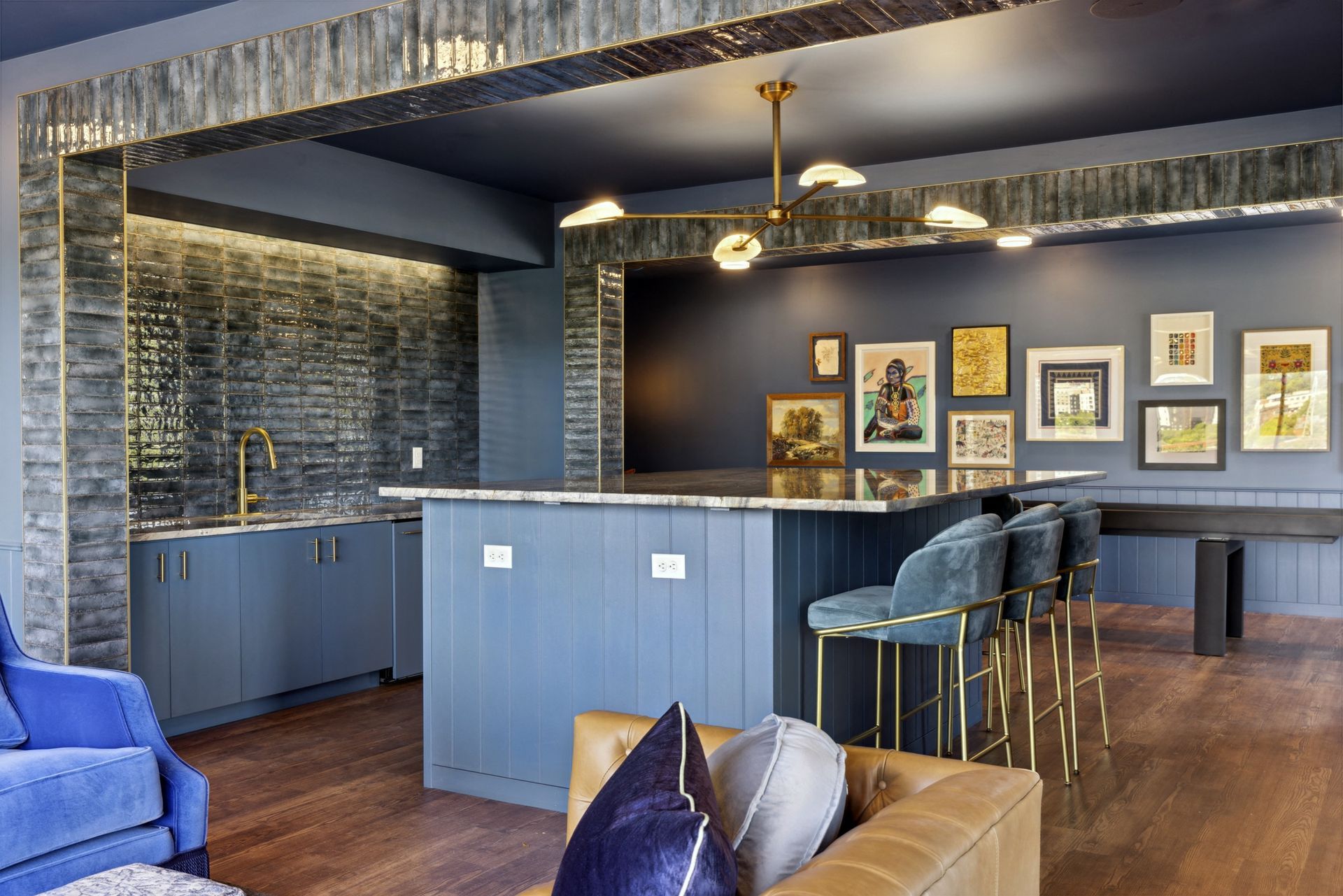 Interior communal lounge with a blue bar, marble countertop, seating, and framed art at Esox House in St. Paul, MN.