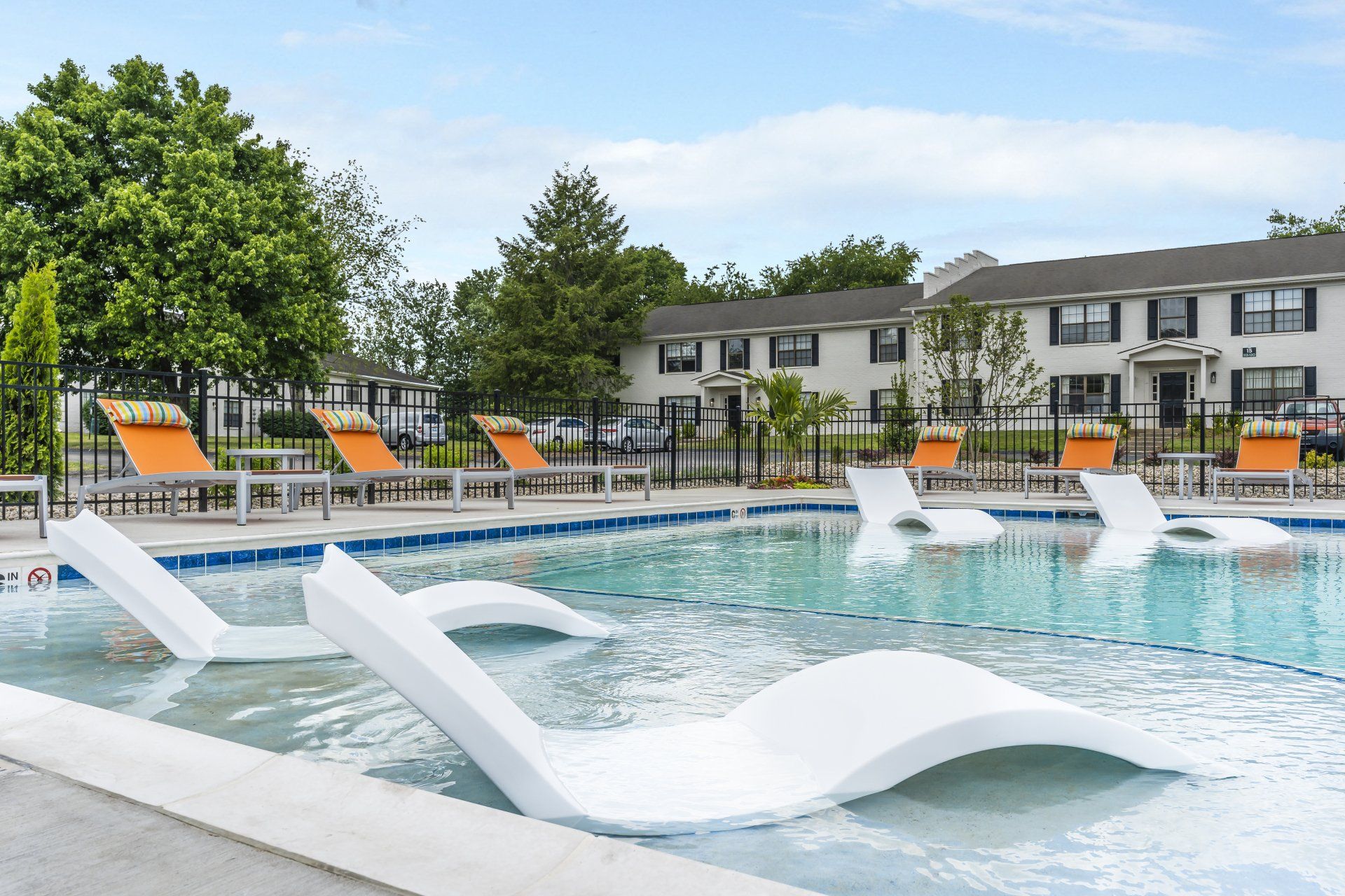 A large swimming pool with a lot of chairs around it at The Colony at the Oaks.