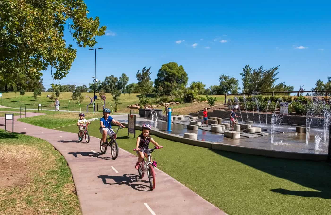 A Group Of Children Are Riding Bikes On A Path In A Park   - Appliance Repairs in Tamworth, NSW