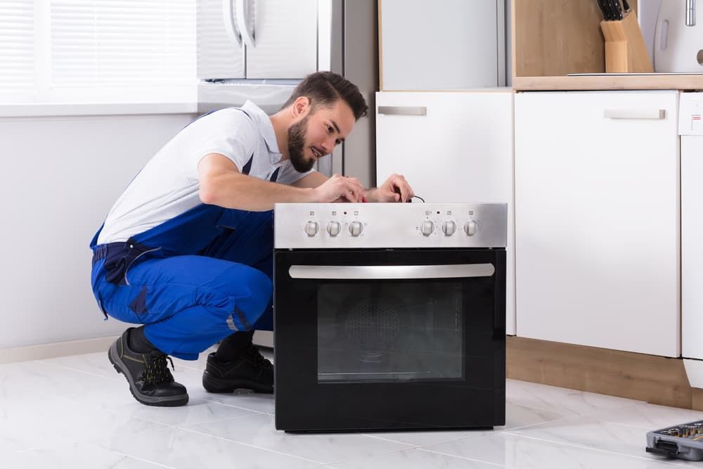 man fixing oven